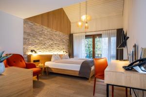 ErmatingenLILIENBERG的一间带床、桌椅的酒店房间