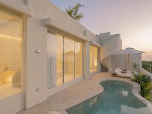 a villa with a swimming pool and a house at NOUR Uluwatu in Uluwatu