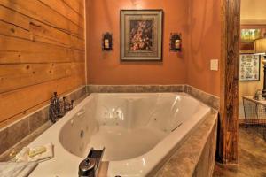 a large white tub in a bathroom with wooden walls at Rustic Lodge Getaway with Large Patio and Pond near Lufkin, Texas in Zavalla