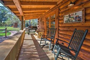 two rocking chairs on a porch of a log cabin at Rustic Lodge Getaway with Large Patio and Pond near Lufkin, Texas in Zavalla