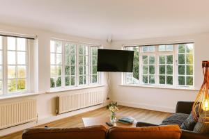 a living room with a couch and a flat screen tv at Kenn Valley View in Doddiscombsleigh