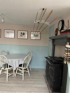 Un comedor con una mesa y sillas y un reloj. en Michaelstow, en Perranporth
