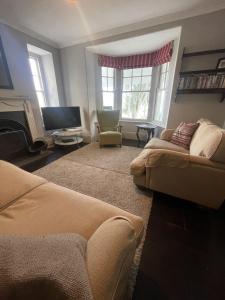 Una sala de estar con un sofá y un televisor. en Michaelstow, en Perranporth 16 fotos más