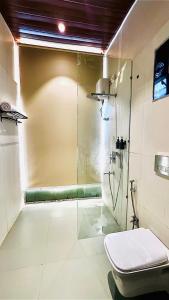 a bathroom with a glass shower with a toilet at The Chalets, Mulshi in Wadgaon