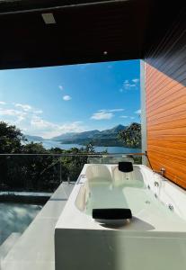 a white bath tub in a room with a large window at The Chalets, Mulshi in Wadgaon