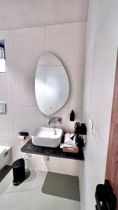 a white bathroom with a sink and a mirror at The Chalets, Mulshi in Wadgaon