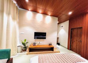 a bedroom with a bed and a tv on a wall at The Chalets, Mulshi in Wadgaon +10 photos