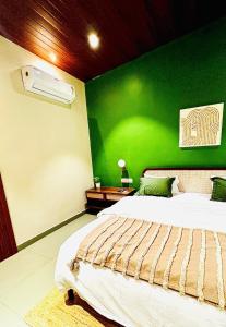a green bedroom with a bed and a green wall at The Chalets, Mulshi in Wadgaon
