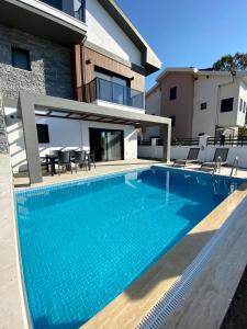 a swimming pool in front of a house at House of ALICE - Villa with Pool near Çalış Beach in Fethiye