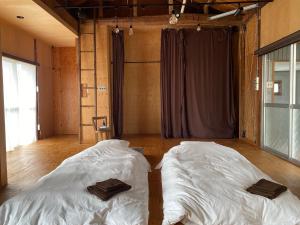 Dos camas en una habitación con sábanas blancas. en コワーキングスペース kuzume Base ゲストハウス 古朴-MOKU-1棟貸の宿, en Konan