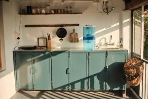 a glass cabinet in a kitchen with a sink at The Attic Library by AVVAs Stays in Bīr
