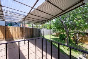 an outdoor deck with a pergola and a fence at The Valley View Guest House in Melbourne