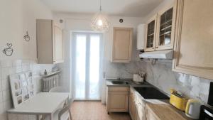 a white kitchen with a sink and a window at Sunrise in Bergamo