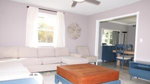 een woonkamer met een witte bank en een tafel bij Bay Beach Bungalow in Town Bank