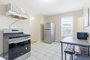 a kitchen with a stainless steel refrigerator and a table at Chic 2BR Apartment Near Branch Brook Park in Newark