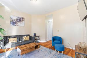 a living room with a couch and a blue chair at Chic 2BR Apartment Near Branch Brook Park in Newark
