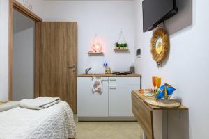 a bedroom with a bed and a kitchen with a sink at L'aurora in San Vito dei Normanni
