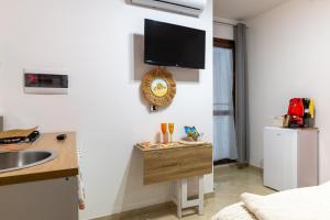 a kitchen with a sink and a counter with a tv on the wall at L'aurora in San Vito dei Normanni +21 photos