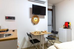 a small kitchen with a sink and a table with chairs at L'aurora in San Vito dei Normanni