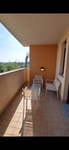a balcony with two chairs and a table and a window at Casa di Mike in Canegrate