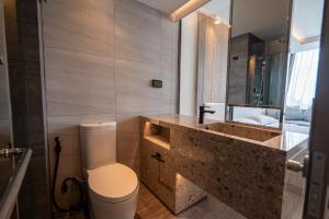 ein Badezimmer mit Waschbecken, Toilette und Spiegel in der Unterkunft Bluphere Residence by Prop Hopper in Na Jomtien + 24 Fotos