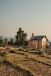 a house in the middle of a field at The Attic Library by AVVAs Stays in Bīr