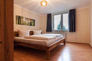 a bedroom with a bed and a large window at Naturpur Ferienhaus in Friedrichsbrunn