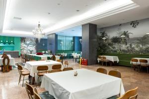 a dining room with tables and chairs and a mural at Fengqi Wutong Holiday Hotel - Changsha Wuyi Avenue Railway Station Metro Station Branch in Changsha