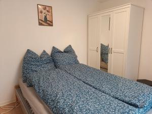a bed with blue pillows in a bedroom at Ferienwohnung Schack in Hoisdorf