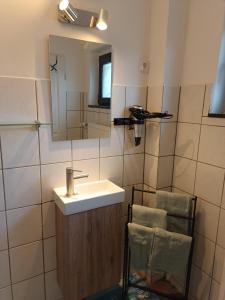 a bathroom with a sink and a mirror and a chair at Ferienwohnung Schack in Hoisdorf