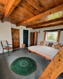 a bedroom with a bed and a chair and a rug at The Attic Library by AVVAs Stays in Bīr