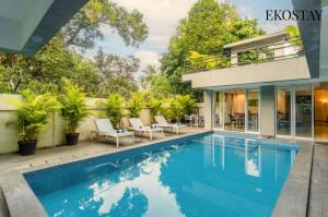 a swimming pool in front of a house at EKOSTAY Gold - AshBee Villa in Kīhīm
