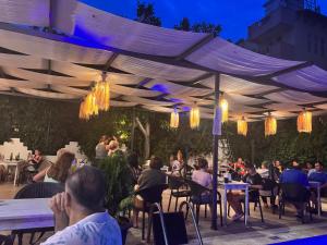 a group of people sitting at tables under a canopy at BEGONYA HOTEL KEMER-All İnclisuve in Antalya