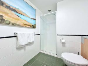 Un baño blanco con inodoro y ducha. en Prime CBD Location- Walk to Spark Area & Queen St, en Auckland 22 fotos más