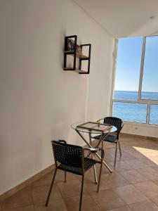 a dining room with a glass table and two chairs at Your dream home in Aouchtame +6 photos