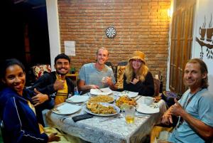 a group of people sitting around a table eating food at New Green View Guest House Kithal Ella in Badulla