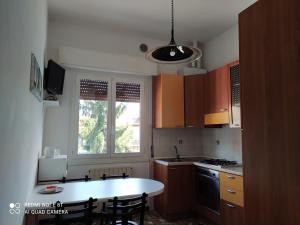 a kitchen with a white table and a window at CASA VACANZE LUNA in Seriate +10 photos