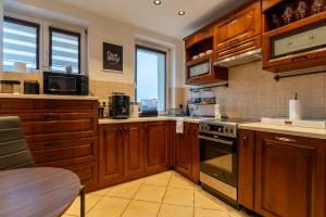 a kitchen with wooden cabinets and a stove top oven at Ratuszove Love - dwie osobne sypialnie, w rynku - by Everslow in Jelenia Góra