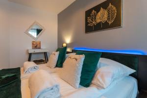 Schlafzimmer mit einem Bett mit grünen und weißen Kissen in der Unterkunft Ratuszove Love - dwie osobne sypialnie, w rynku - by Everslow in Jelenia Góra