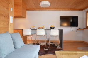 a living room with a table and a bar with stools at Adelaide A 03 in Grimentz