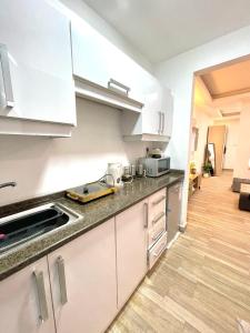 een keuken met witte kasten en een houten vloer bij studio with balcony in Amman