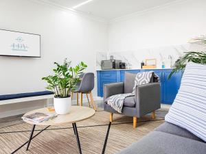 een woonkamer met twee stoelen en een tafel bij La Dolce Vita Gordon’s Bay in Gordonsbaai