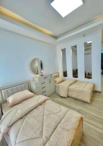 twee bedden in een kamer met twee spiegels bij studio with balcony in Amman