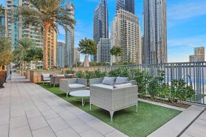 a balcony with chairs and tables and a city skyline at Luxurious 3 BR with Burj Khalifa View in Downtown in Dubai