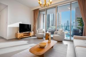 a living room with a couch and a tv at Luxurious 3 BR with Burj Khalifa View in Downtown in Dubai
