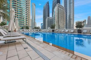 a swimming pool with chairs and umbrellas on a building at Luxurious 3 BR with Burj Khalifa View in Downtown in Dubai