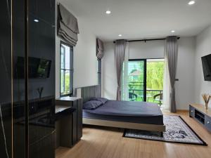 ein Schlafzimmer mit einem Bett und einem großen Fenster in der Unterkunft Saint Sean Saraphi in Chiang Mai