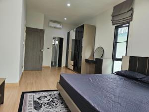 ein Schlafzimmer mit einem Bett und einem großen Fenster in der Unterkunft Saint Sean Saraphi in Chiang Mai