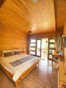 a bedroom with a large bed and a wooden ceiling at Lá Homestay in Ðak Lao