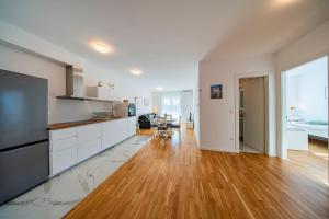 a kitchen with white cabinets and a hard wood floor at Flex SelfCheckIns 191 - Zagreb - 2 Bedrooms - Parking - Loggia in Zagreb +29 photos